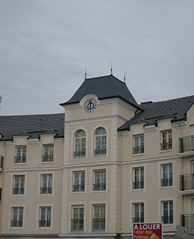 Façade extérieure d'un immeuble avec une horloge monumentale huchez à Morangis